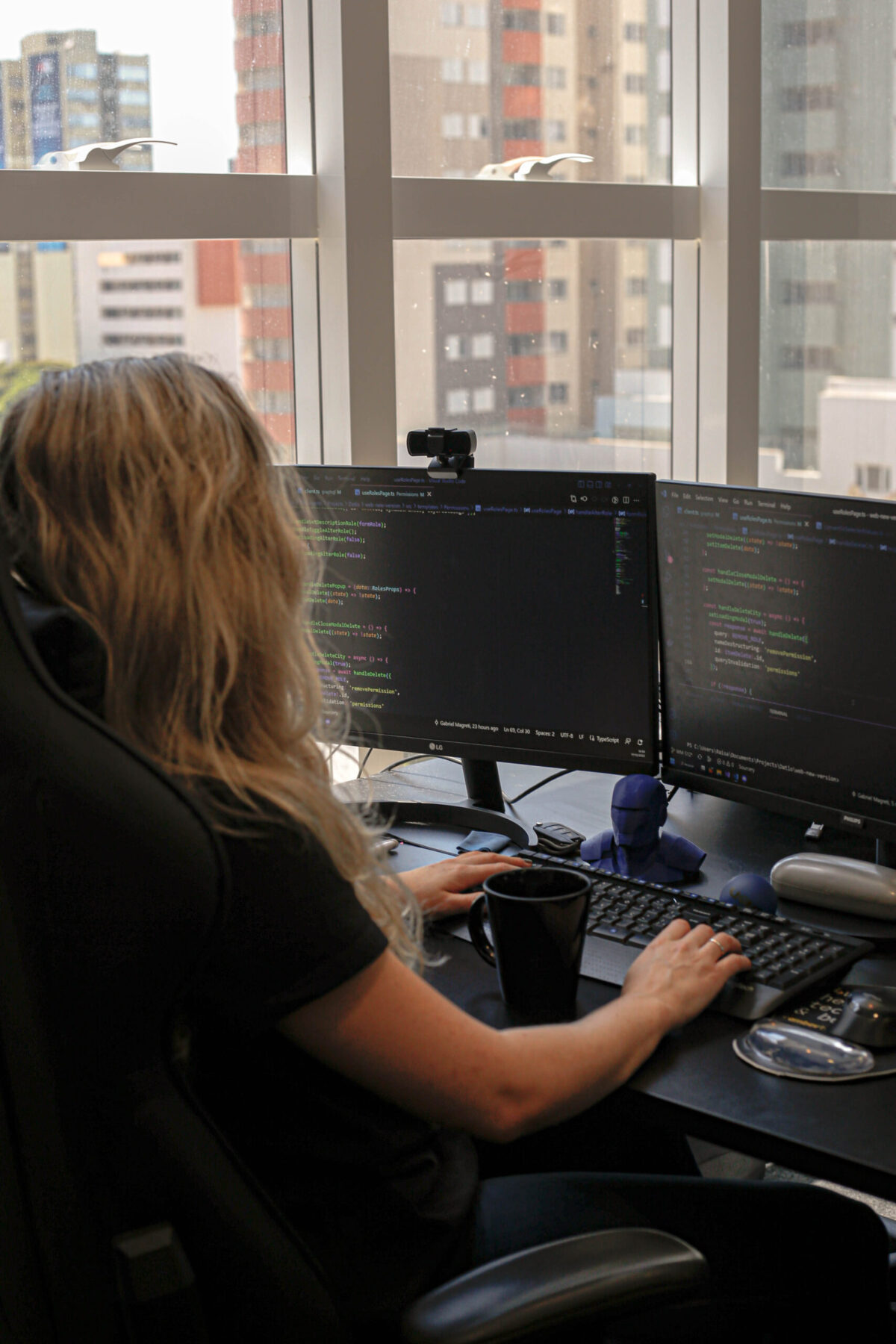 Ambiente de trabalho da Datlo, com Raisa programando em sua mesa de escritório.